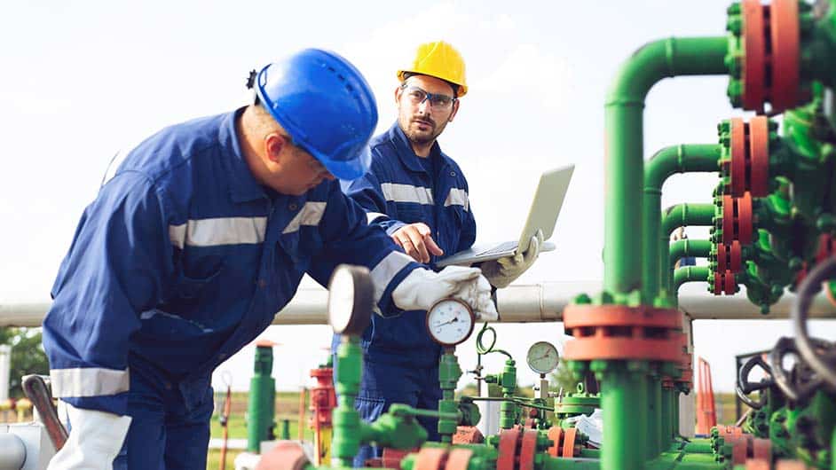 Men-examining-gauges-at-industrial-facility