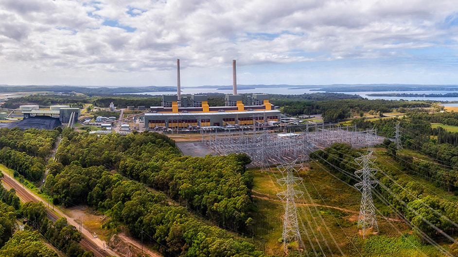 An aerial view shows 4 towers and dozens of power transmission lines running directly to a power generation plant..